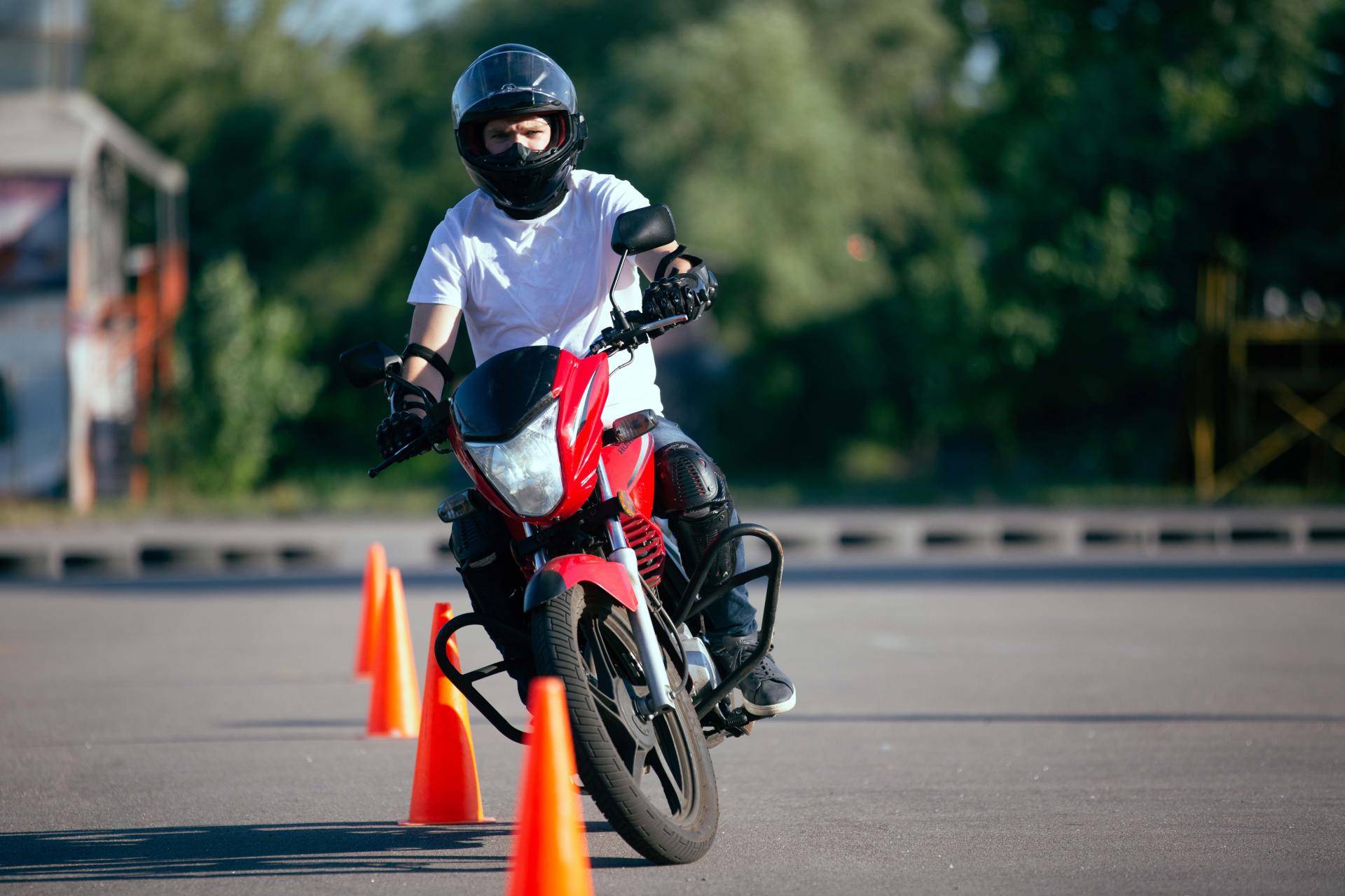 Sedicenne con casco integrale e equipaggiamento completo su una moto da 125 cc, pronto per l'esame pratico della patente A1