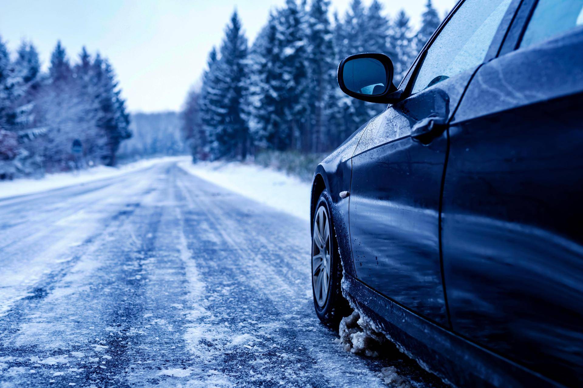 Catene da neve montate su pneumatico di un'auto in condizioni invernali su strada innevata