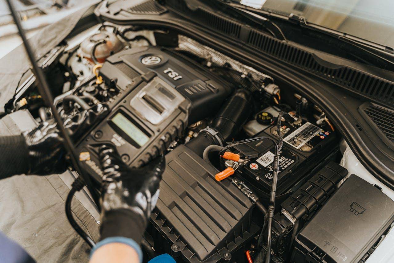 meccanico testa lo stato della batteria di un'auto durante un tagliando auto