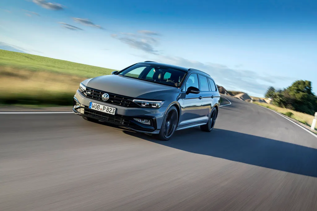 Volkswagen Passat Variant grigia su strada panoramica &ndash; station wagon di riferimento in Europa con grande bagagliaio e motori efficienti.