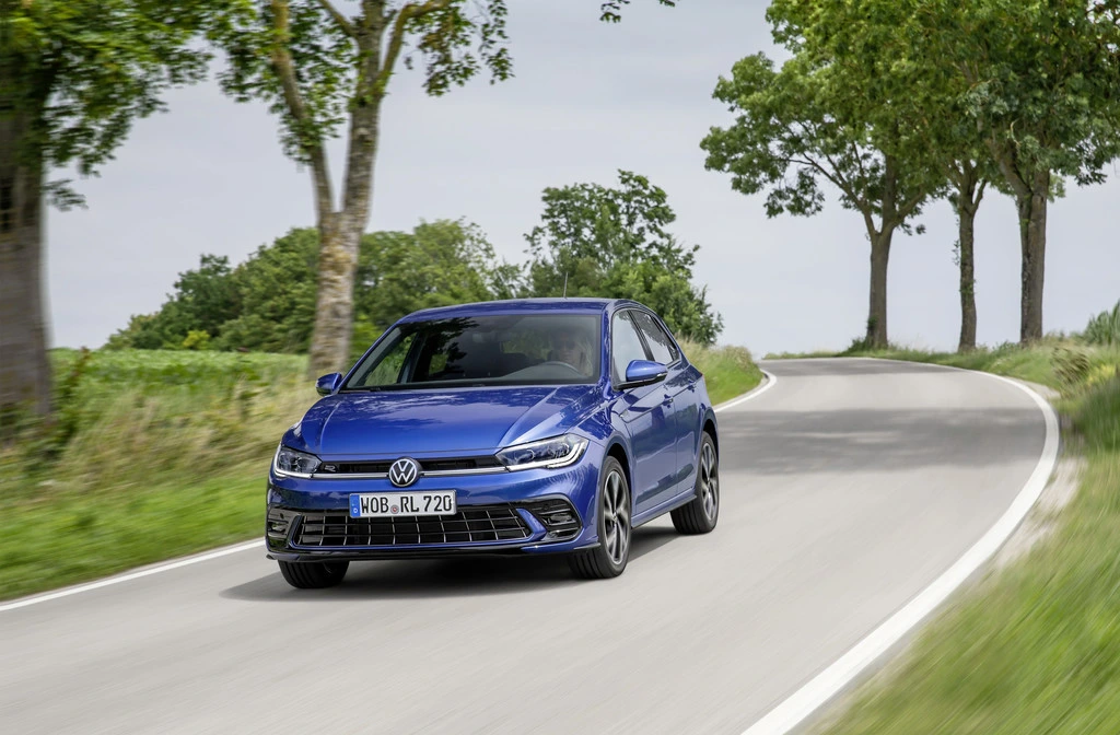 volkswagen polo blu viaggia su una strada