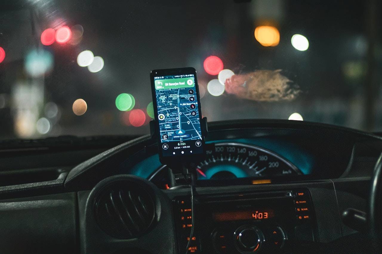 abitacolo vettura con app navigazione visualizzata su smartphone